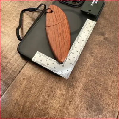 IPhone 14 black case with wooden surfboard accessory and metal box opener frame ruler