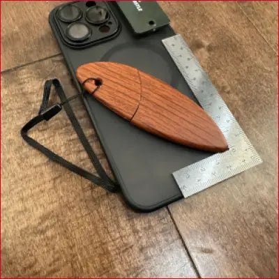 Black phone case with wooden surfboard-shaped USB drive.