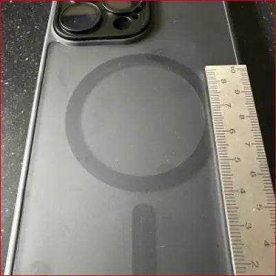 Gray iPhone 14 Pro Max with stainless frame and MagSafe ring inside frame ruler