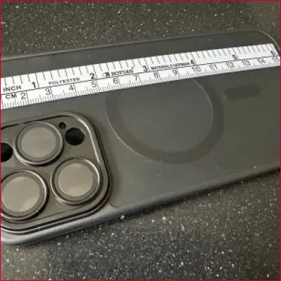 Black phone case with camera lens openings and silver ruler for iPhone 15 Pro
