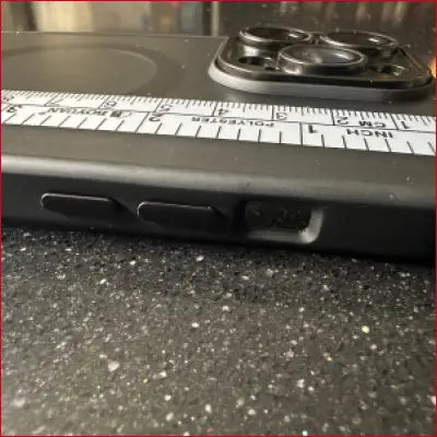 Black iPhone 15 Pro case with camera lens protector and silver ruler for precise measurements