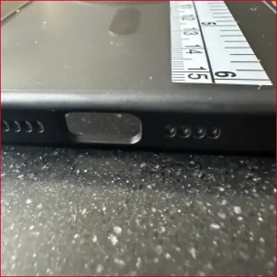 Black smartphone with ports and speaker holes in iPhone 15 Pro Black Case Silver Ruler