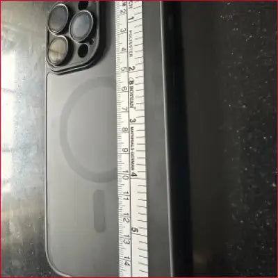 Black phone with camera lenses and measuring tape showcasing iPhone 15 Pro Black Case Silver Ruler