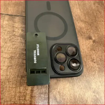 Black phone with iPhone 16 Plus black case and survival whistle for outdoor safety