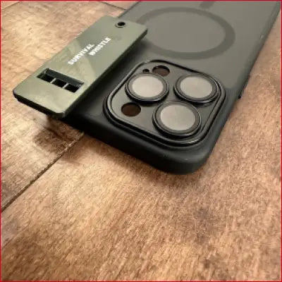 Black iPhone 16 Plus case with camera lenses and green survival whistle