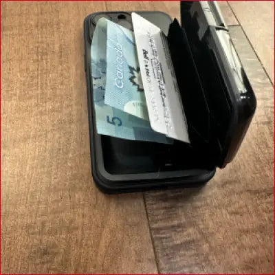 Black wallet case with Canadian money and card.