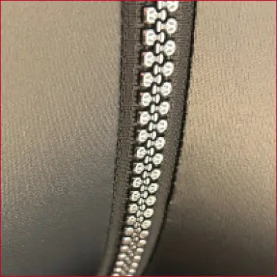 Zipper with metallic teeth on black fabric of Sexy Skull Teeth Crotch Zipper Faux Leather Leggings