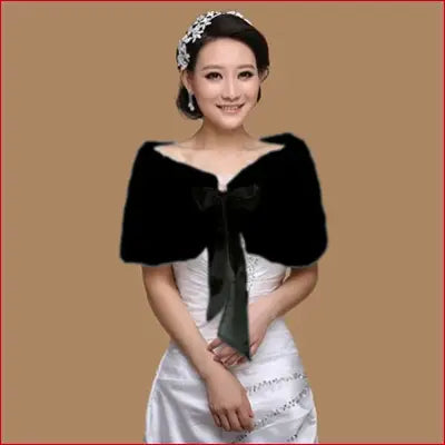 Woman wearing a black faux fur cape with satin ribbon bow for women winter warmth