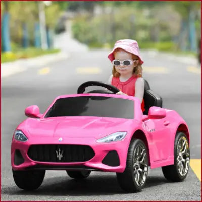 Pink toy car with child driver in 12V Kids Ride-On Car with Remote Control and Lights