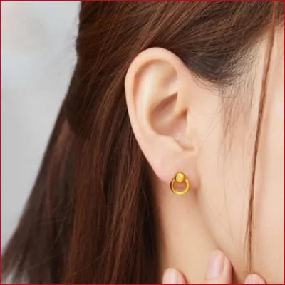 Gold hoop earring worn in earlobe, featured in Stunning Round Stud Earrings collection