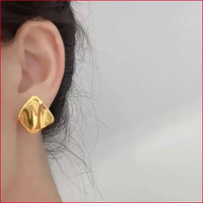 Gold Lotus Flower earring in 24K gold with textured surface worn on earlobe