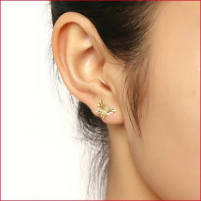 Gold butterfly-shaped stud earring worn in earlobe showcasing 24k Gold Sunflower design