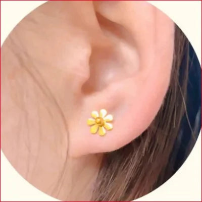 Flower-shaped 24k Gold Sunflower Stud Earrings with pearl center worn on earlobe