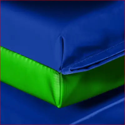 Blue and green padded corner of a durable exercise mat for home workouts and gym use