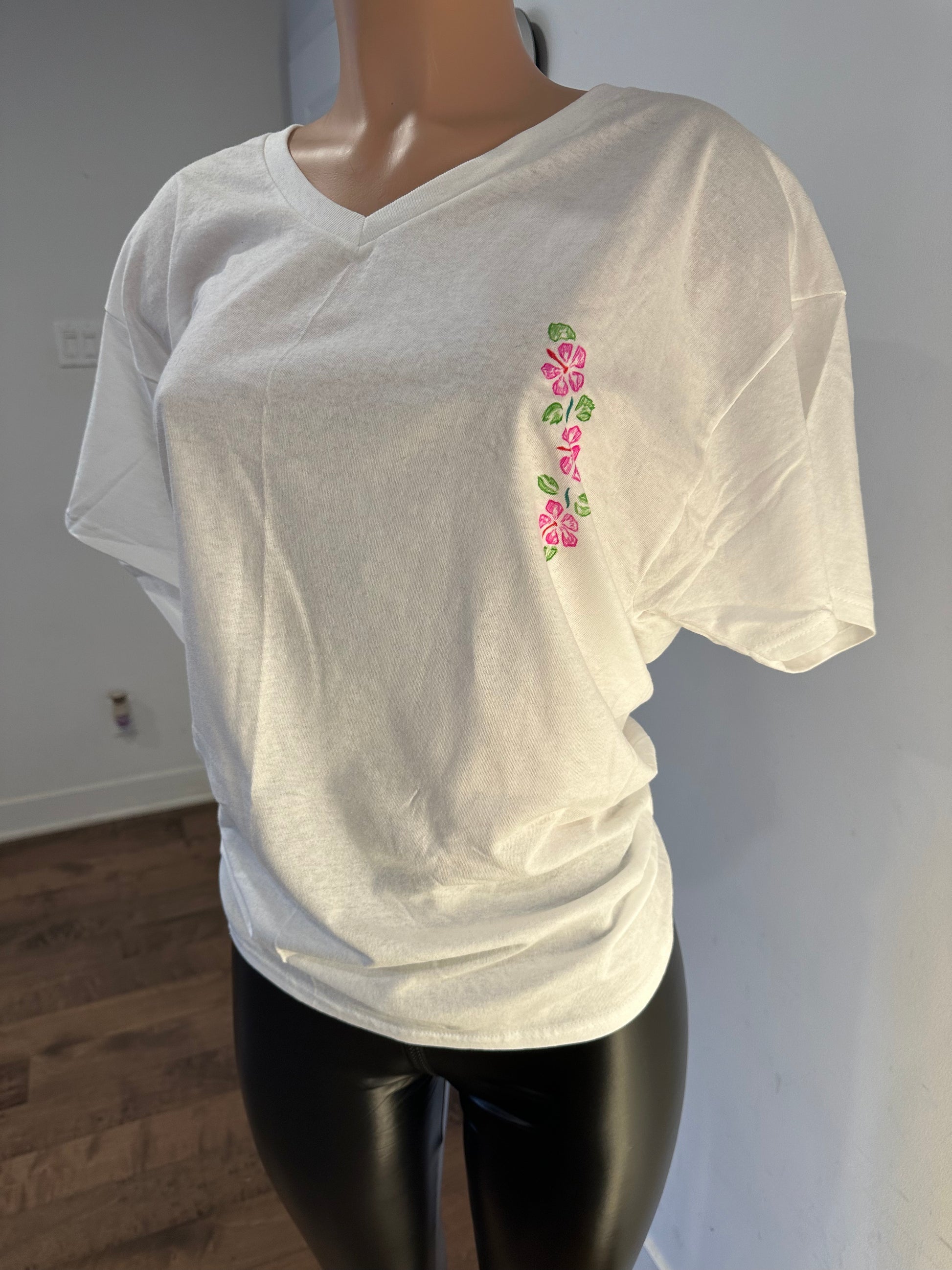 Handmade white women’s v-neck t-shirt featuring floral embroidery on the side