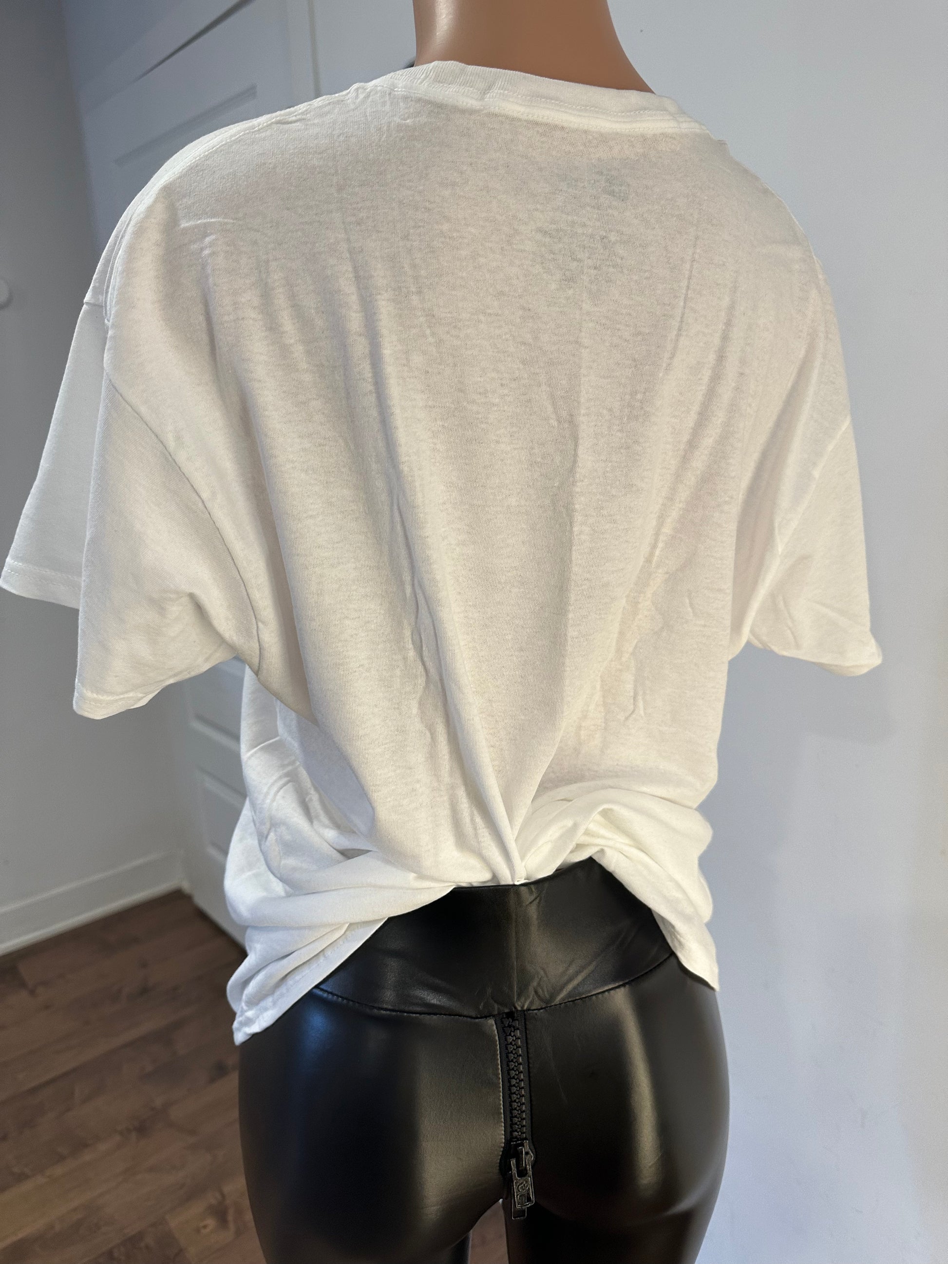 Handmade white v-neck t-shirt with leaves drawing worn over black leather pants