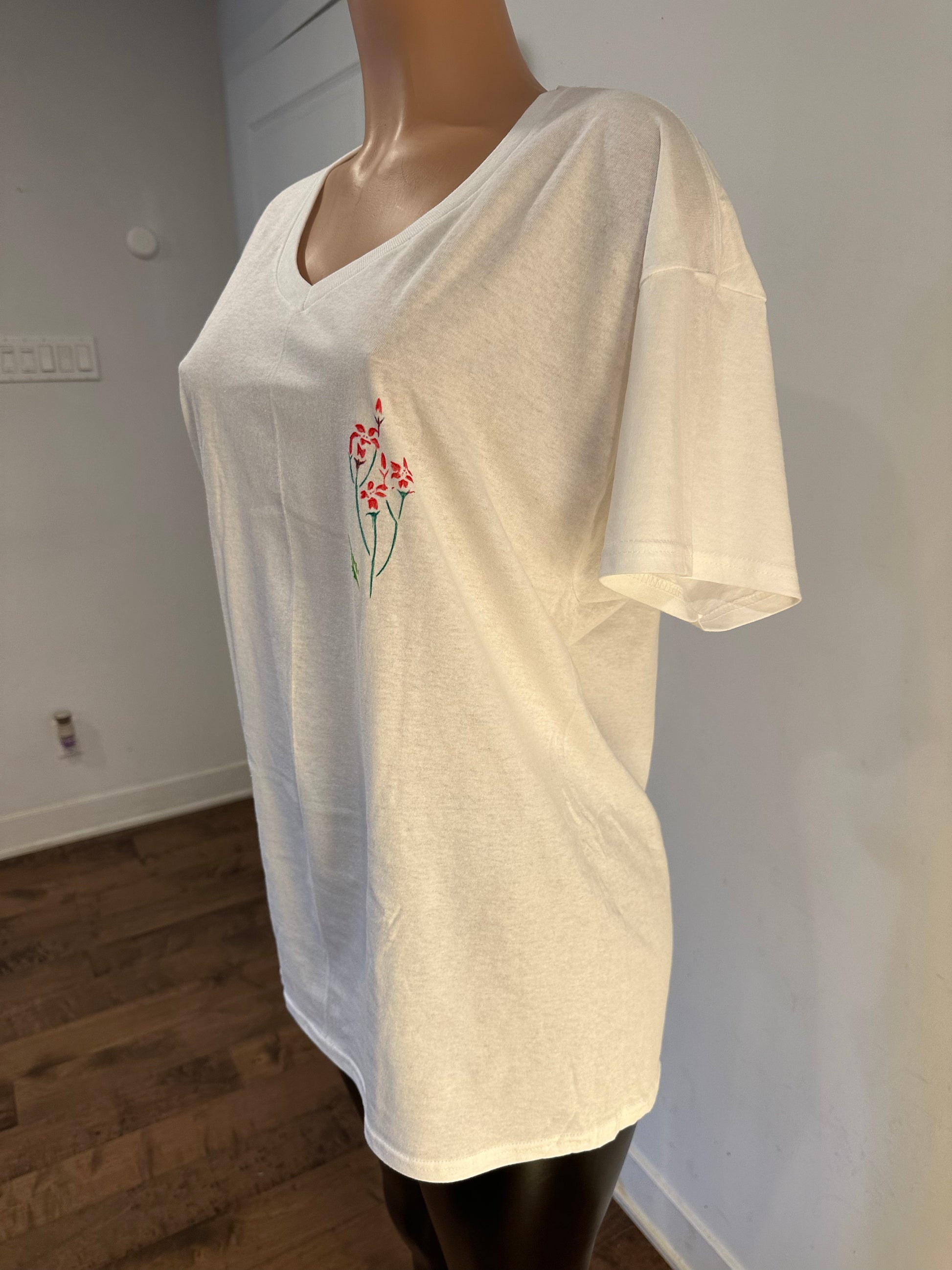 Handmade white v-neck t-shirt featuring a floral chest embroidery and palm tree drawing