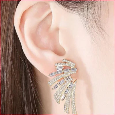 Ornate angel wings drop earrings with Swarovski Crystals, elegantly worn on an ear lobe