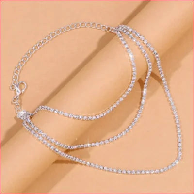 Stylish silver ankle bracelet featuring a multi-strand design with sparkling crystals