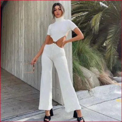 Woman in a white turtleneck cutout knitted jumpsuit, stylish and chic for cocktails