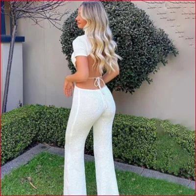 Woman in a white turtleneck cutout knitted crop top and matching wide-leg pants