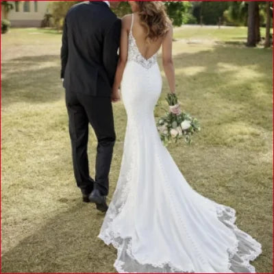 Backless sleeveless wedding dress bridal gown with lace details and a flowing train