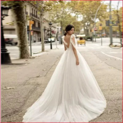 Elegant Traditional Tulle Backless Wedding Dress in White with flowing train