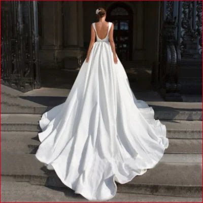 Elegant backless wedding dress in white with a flowing train and low back design