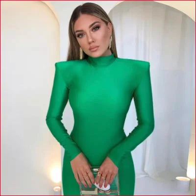 Woman in a vibrant green bodycon long sleeves club party dress with exaggerated shoulders