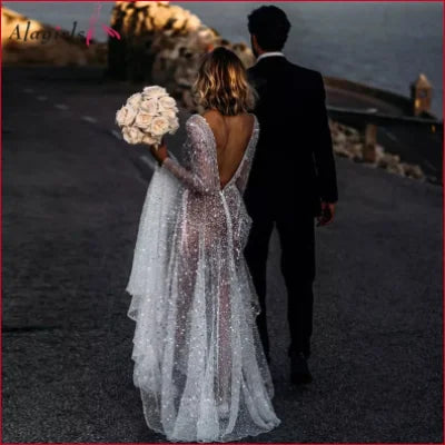 Bride and groom walking together with white boho lace sheer backless wedding dress