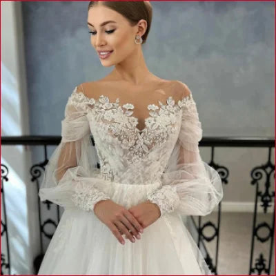 Elegant long sleeves bridal gown in white with lace details and sheer sleeves