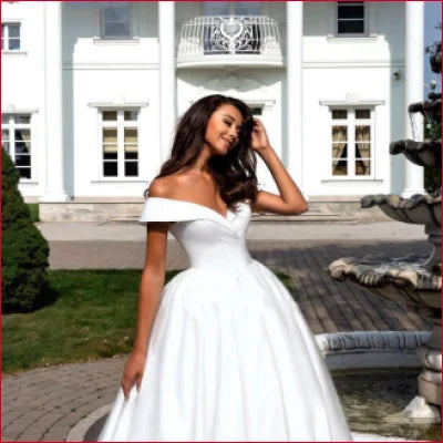 Woman in elegant off-shoulder satin bridal gown with full skirt for weddings