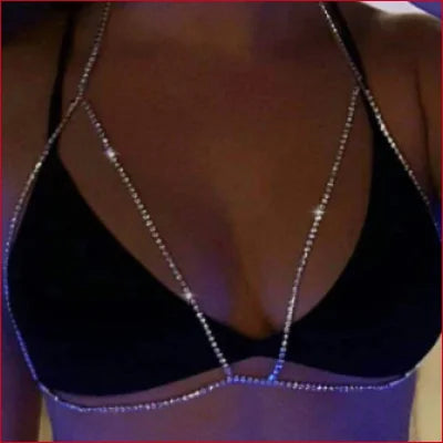 Black bikini top with rhinestone necklace accentuating breast cleavage contour