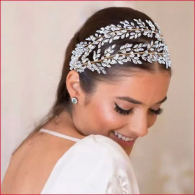 Smiling woman wearing an ornate silver bridal headpiece as a wedding hair accessory