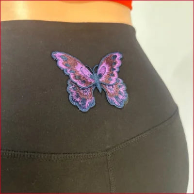 Colorful purple butterfly tattoo on lower back, showcasing Butterfly Leggings Yoga design