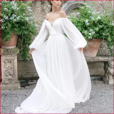 Flowing white chiffon wedding dress with voluminous sleeves and sweeping skirt