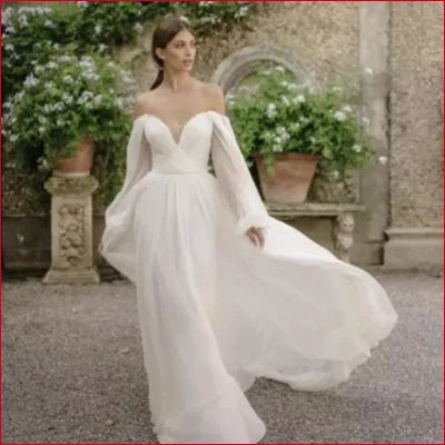 Elegant off-shoulder chiffon wedding dress in ivory and white with flowing sleeves