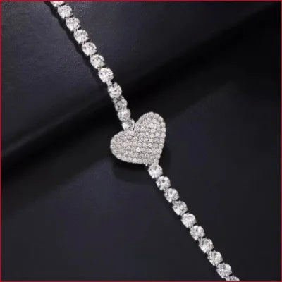 Diamond-encrusted heart jewelry on a sparkling tennis bracelet with rhinestones cleavage