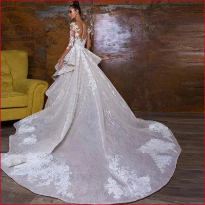 Ornate white wedding gown with detachable train embroidered lace and sheer sleeves