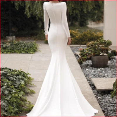 Elegant white mermaid wedding gown with long boho sleeves and flowing train