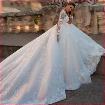 Ornate ivory wedding gown with lace sleeves and a voluminous skirt design