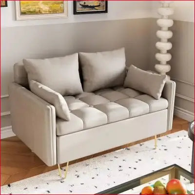 Beige tufted loveseat with gold legs, a stylish faux leather love seat with lift-up storage box