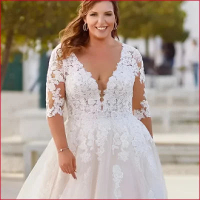 White lace wedding dress with plunging neckline and sheer half sleeves for bridal elegance