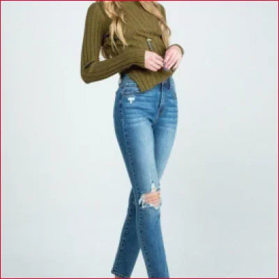 Destroyed skinny denim jeans with clean hem and rips at the knees styled with a green top