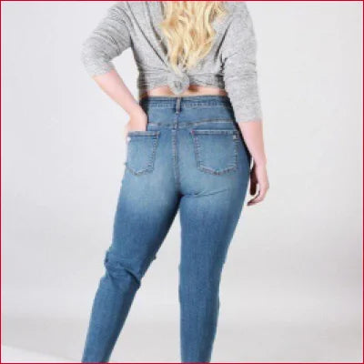 Blue denim super stretchy skinny jeans worn by a blonde with a gray top and destroyed knees