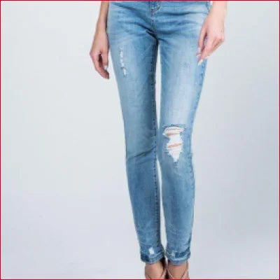 Distressed light blue skinny jeans with rips, medium-light wash and crotch zipper detail