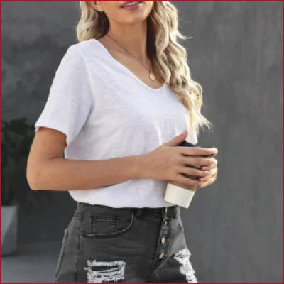 Woman in white t-shirt and high waist denim shorts with frayed hem in classic style