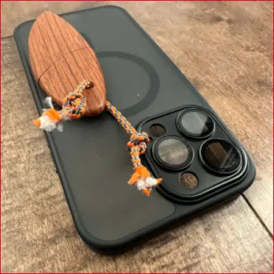 Black smartphone with wooden charm showcasing iPhone 14 Plus Black Case Box Letter Opener