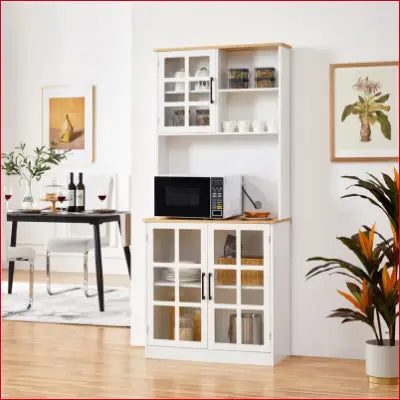 White and wood kitchen pantry with cabinets and open shelves featuring glass doors