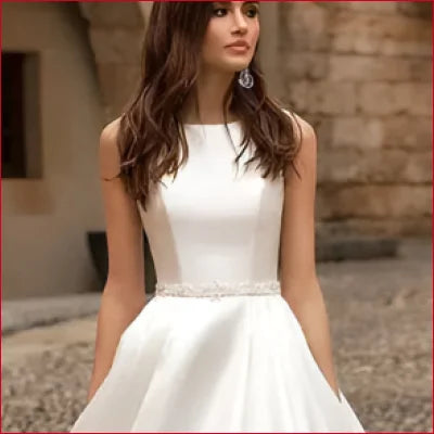 White sleeveless wedding dress with lace back, fitted bodice, and full skirt design